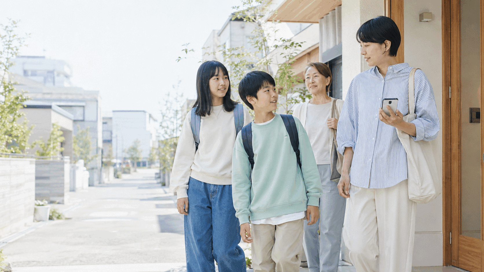 家の前で会話する子ども、母親、祖母